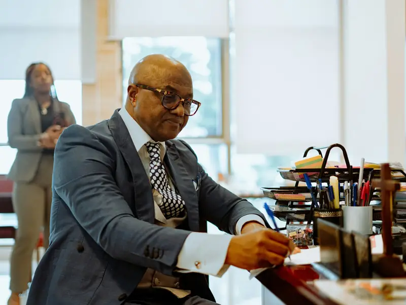 A professional signing papers at his office desk